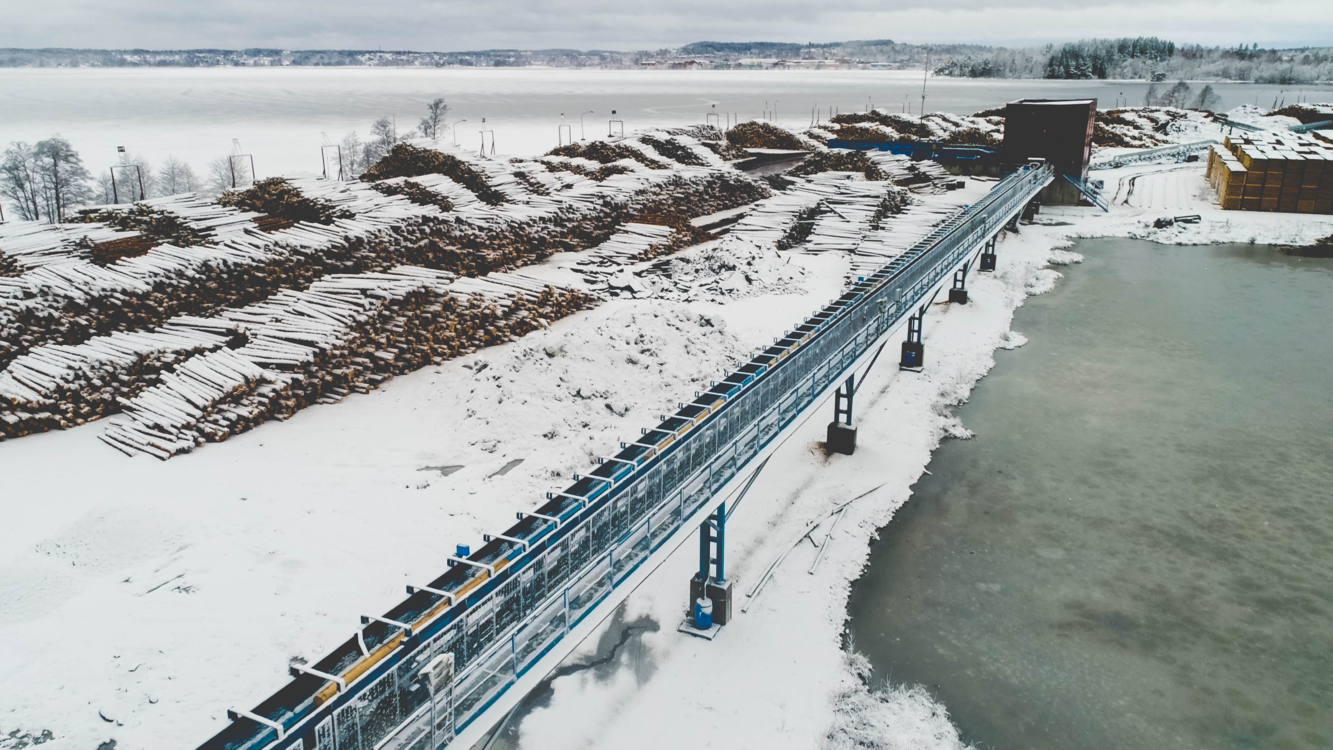 Snowy aerial view of a timber yard and conveyor system