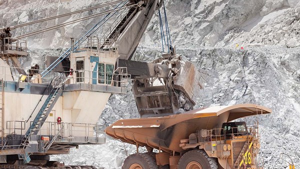 Electric rope shovel loading a dump truck in an open pit mine