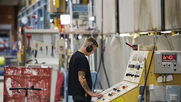 A man wearing ear defenders working at a control panel