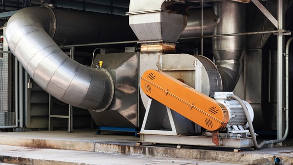 Belt-driven fan, electric motor, and large pipes in industrial setting